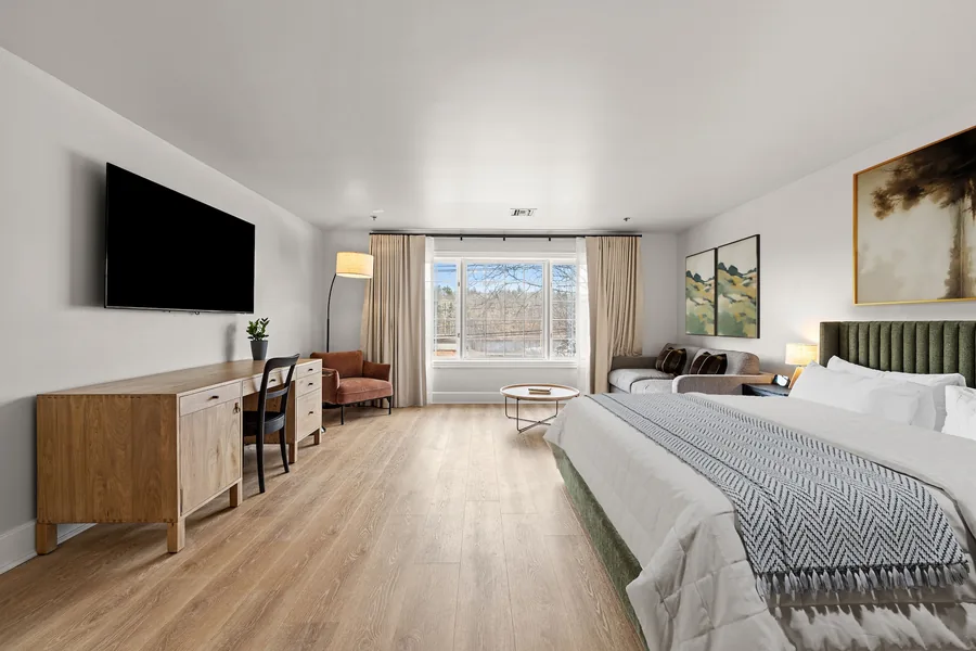 King Suite with a green upholstered headboard and oak floors