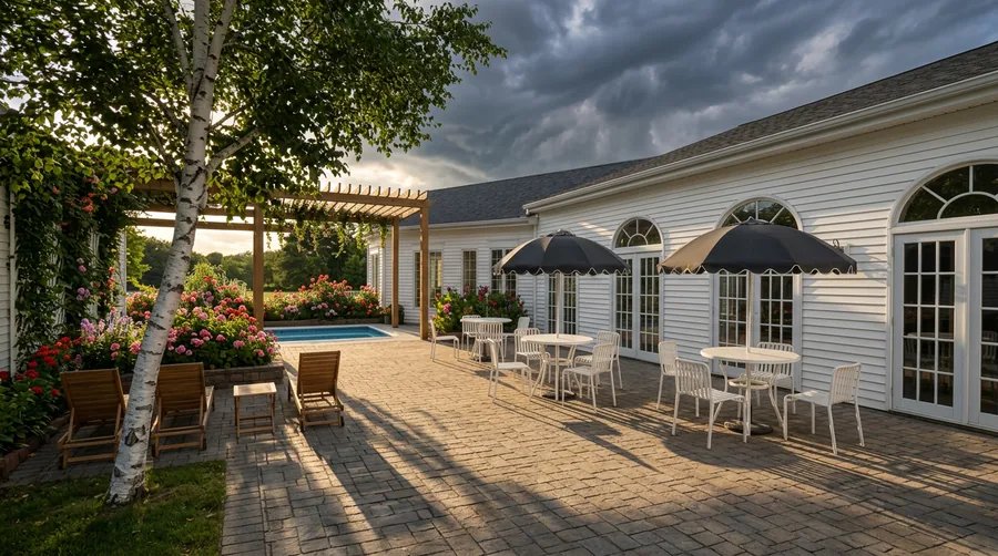 Artist's impression: the courtyard terrace with bistro tables under scalloped umbrellas at golden hour